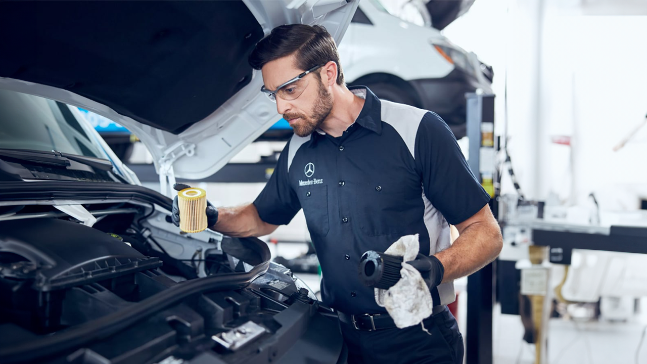 Mécanicien Mercedes-Benz travaillant sur un capot de véhicules Mercedes-Benz